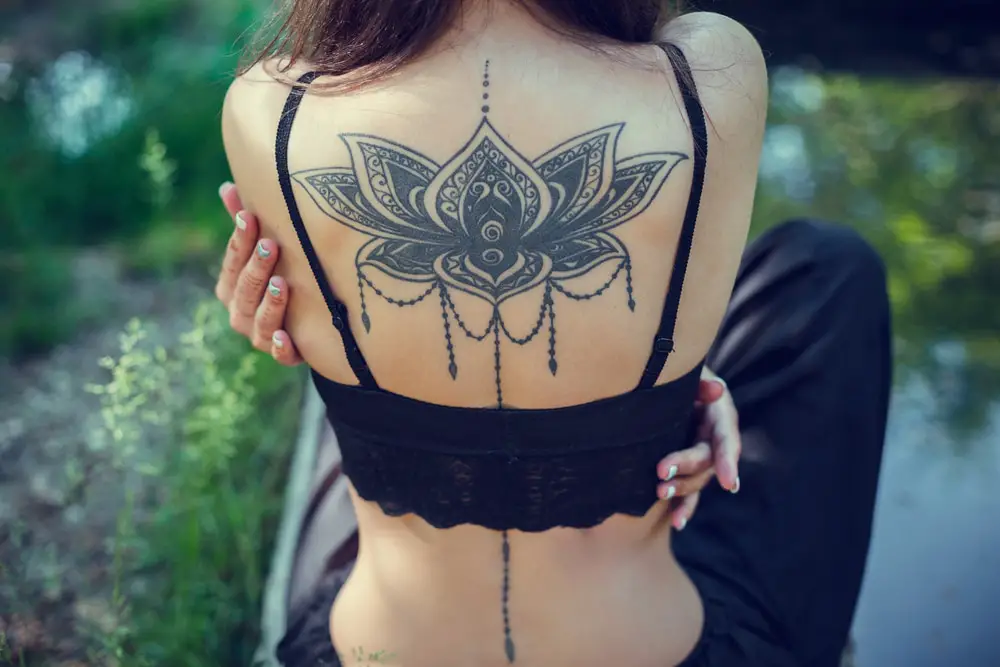 huge black back tattoo on young fit women