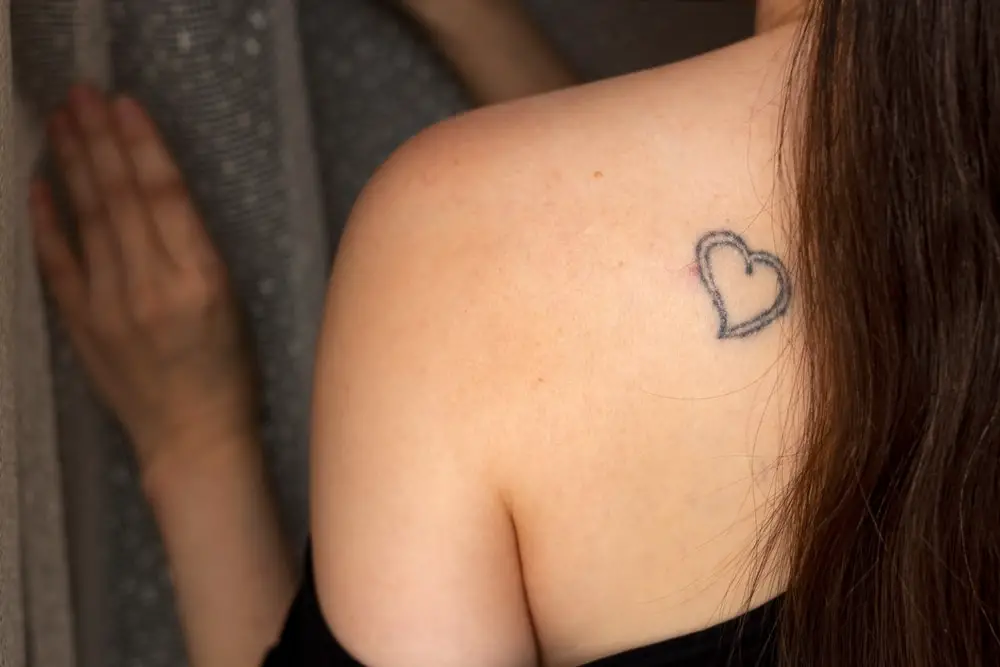 small heart back tattoo on womens upper back