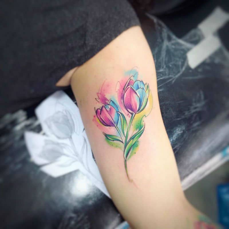 Fine line tulip tattoo on the shoulder