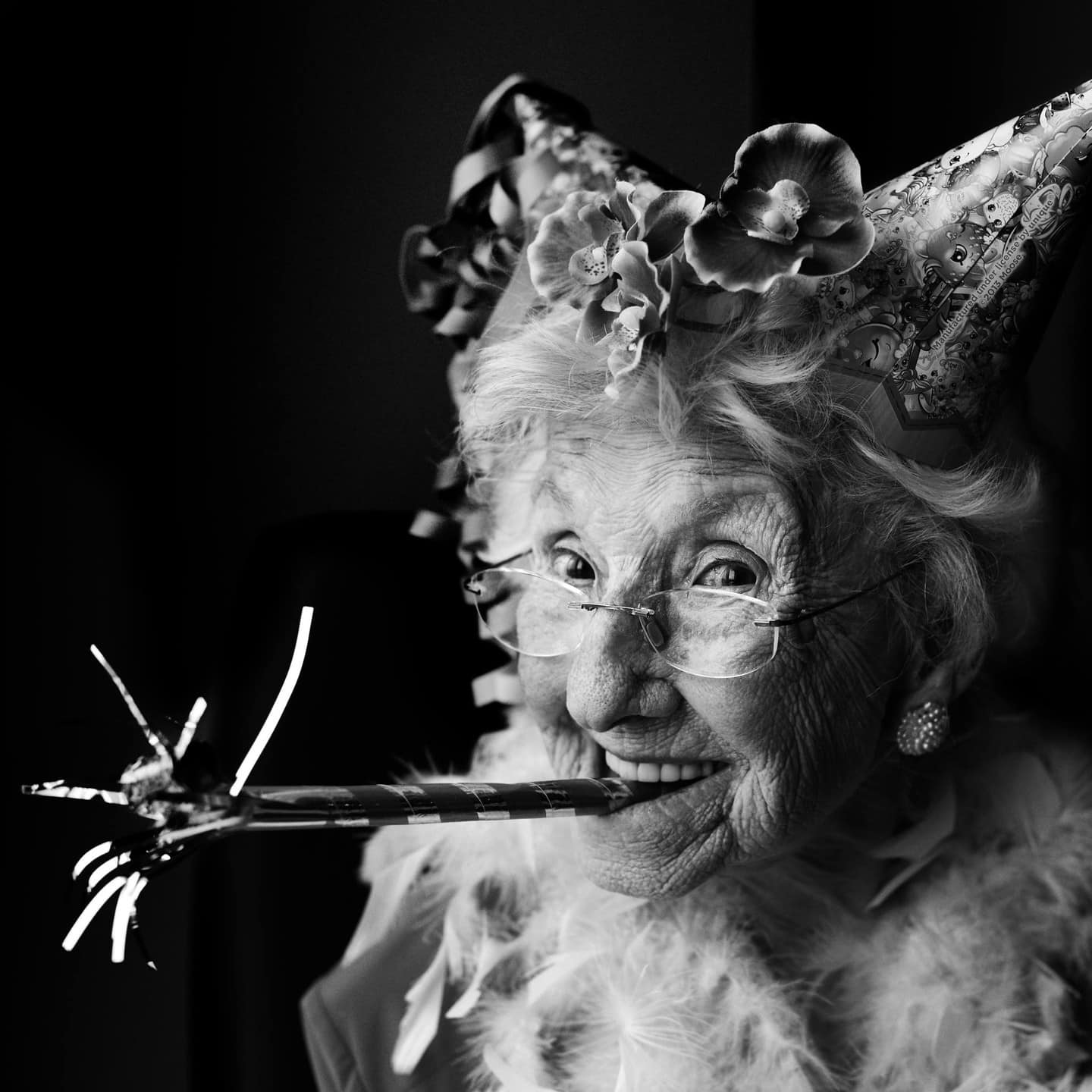 an elderly woman with birthday hat