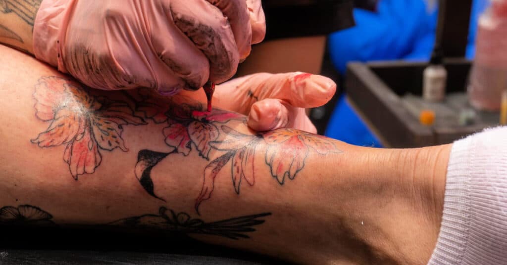 tattoo being put on mans calf