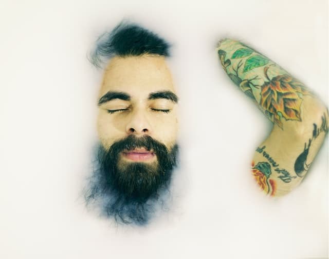 bearded man with arm tattoos