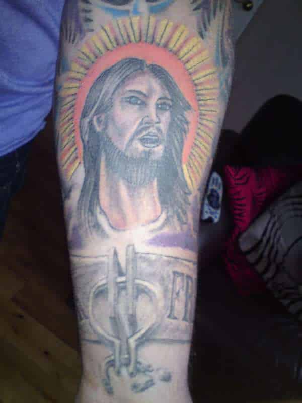 colourful jesus face tattoo design on mans arm