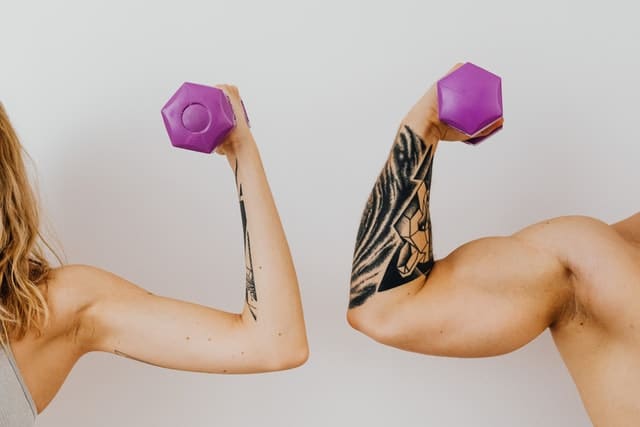male and female with tattoos working out