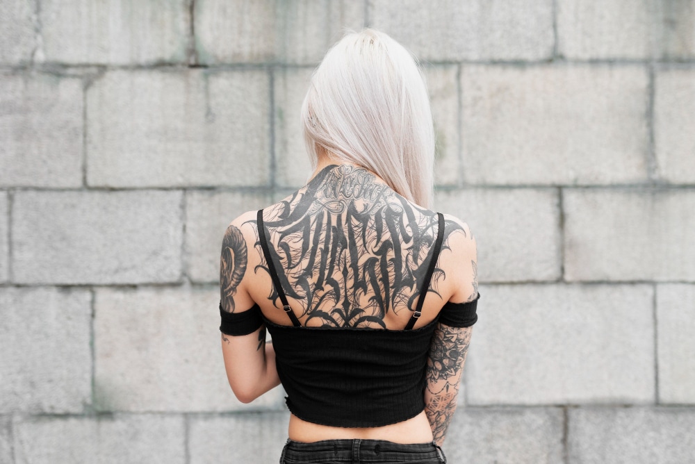 back tattoo and arm sleeve on white haired women