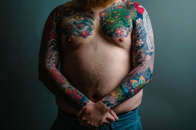 old man with colorful arm and chest tattoos