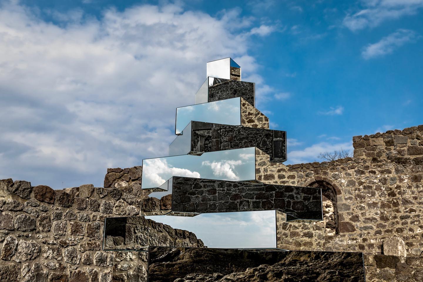 a stair of mirror art installation reflecting brick walls