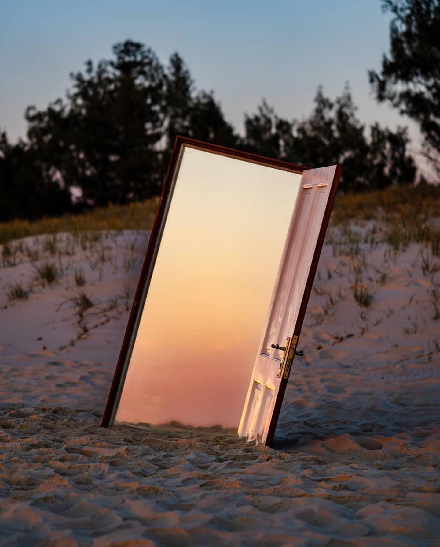 an art installation of the door and a mirror on the opposite side reflecting the colors of sunset