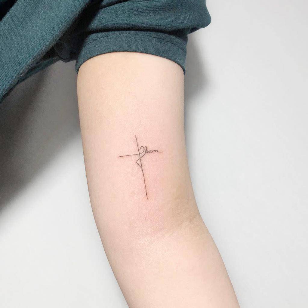 small cross tattoo on womens bicep