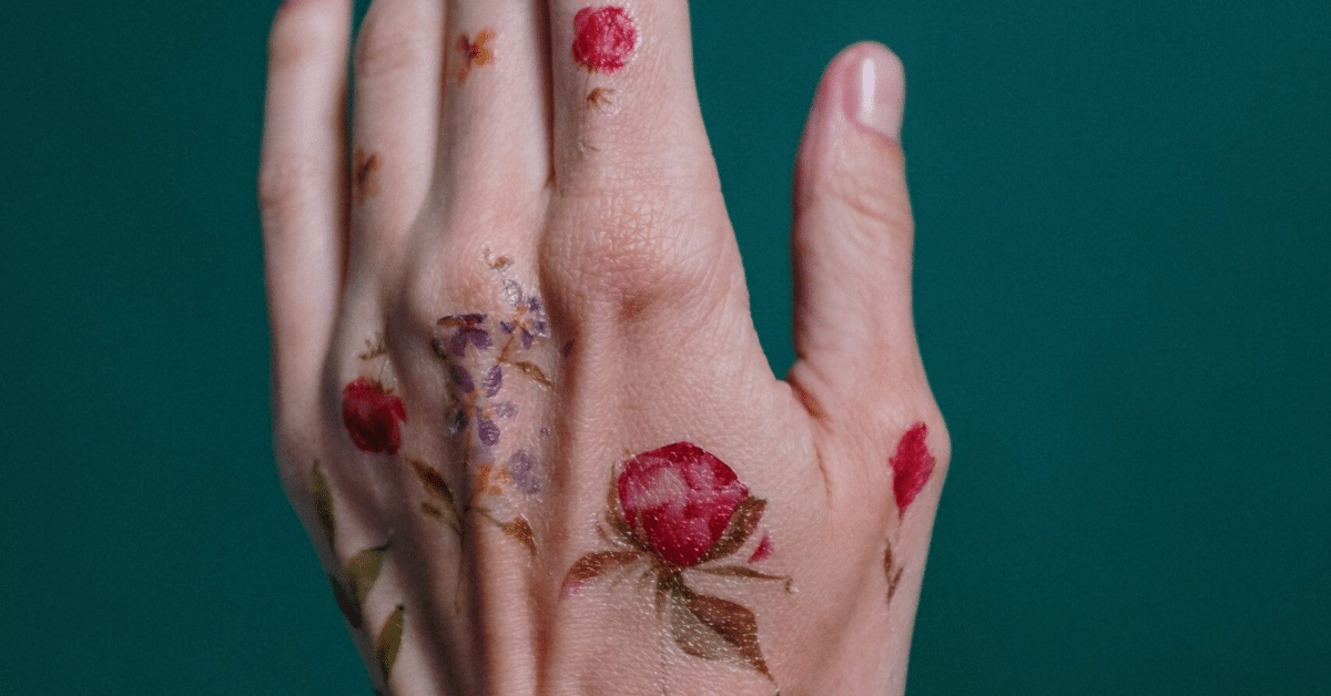 a hand covered in floral temporary tattoos