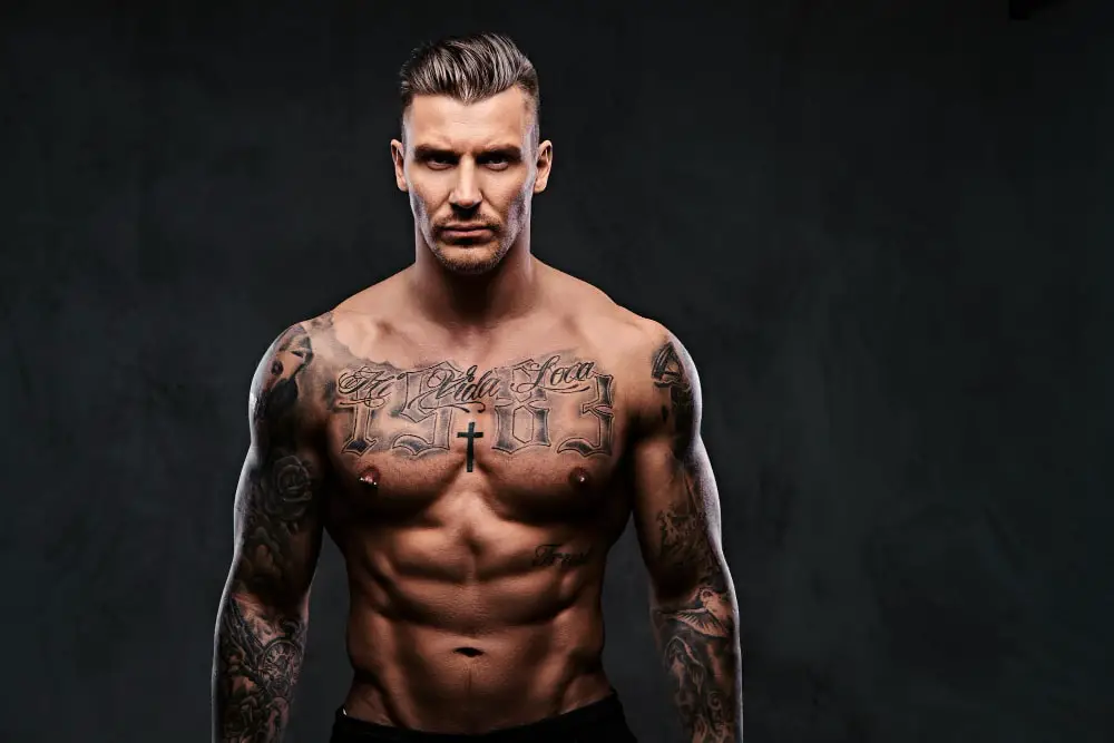 strong male model with no shirt and with many body tattoos