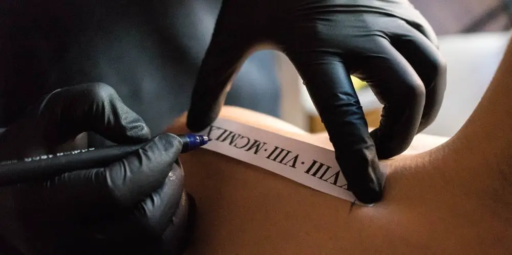 tattoo artist preparing to put a tattoo on a clients shoulder