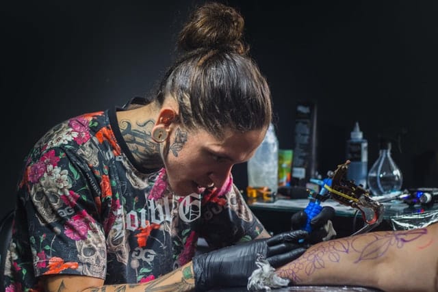 tattoo artist doing arm tattoo