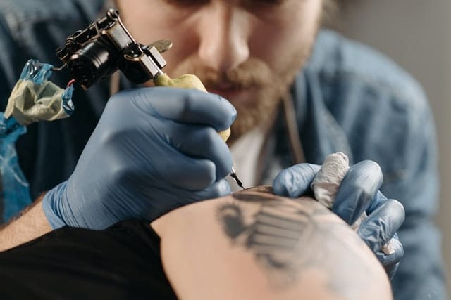 tattoo artist doing arm tattoos