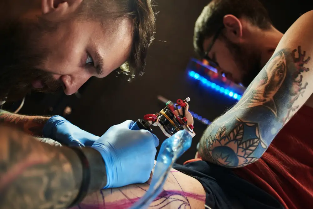up close of a tattoo artist drawing a colourful tattoo