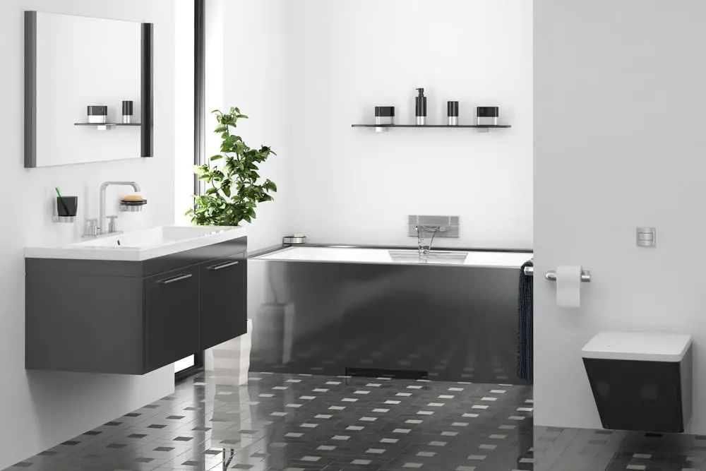 a bathroom design with with glossy black tiles with square pattern black wall mounted storage, drop in tub and chrome bathroom fixtures