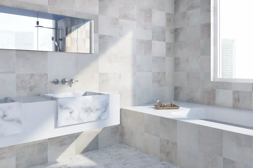 an ethereal bathroom design with creamy white gray and rose gold marble, walk in tub and white and gray twin lavatory