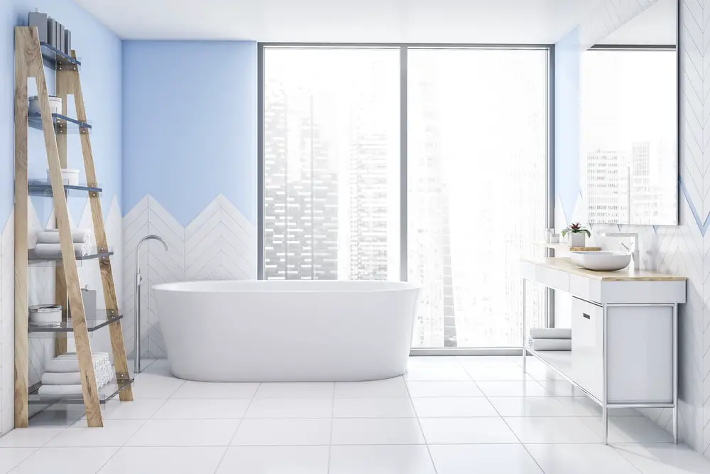 powder blue wall with freestanding white bath tub and panoramic window