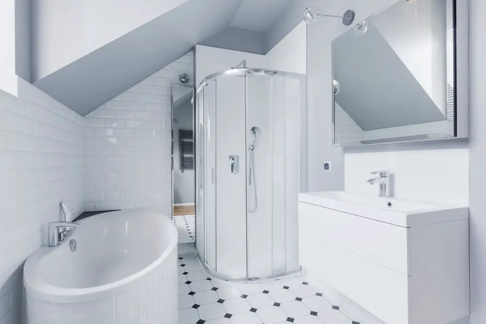 white bathroom design with accents of black and white floor tiles with diamond patterns and walk in shower