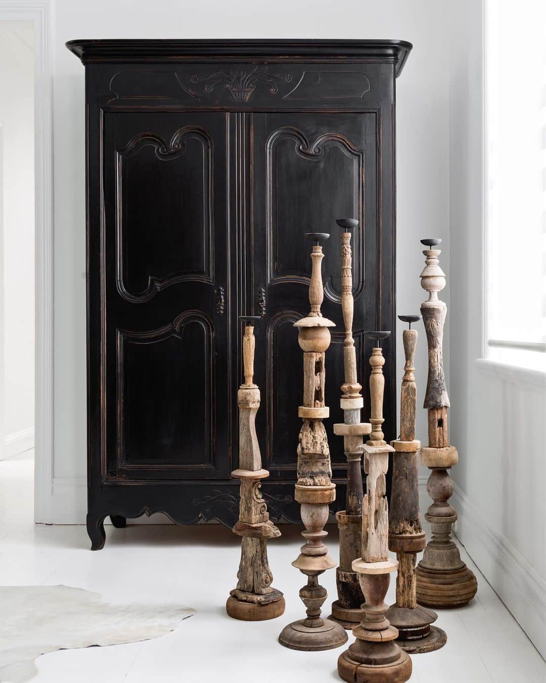 a black wooden cabinet with wooden candlesticks