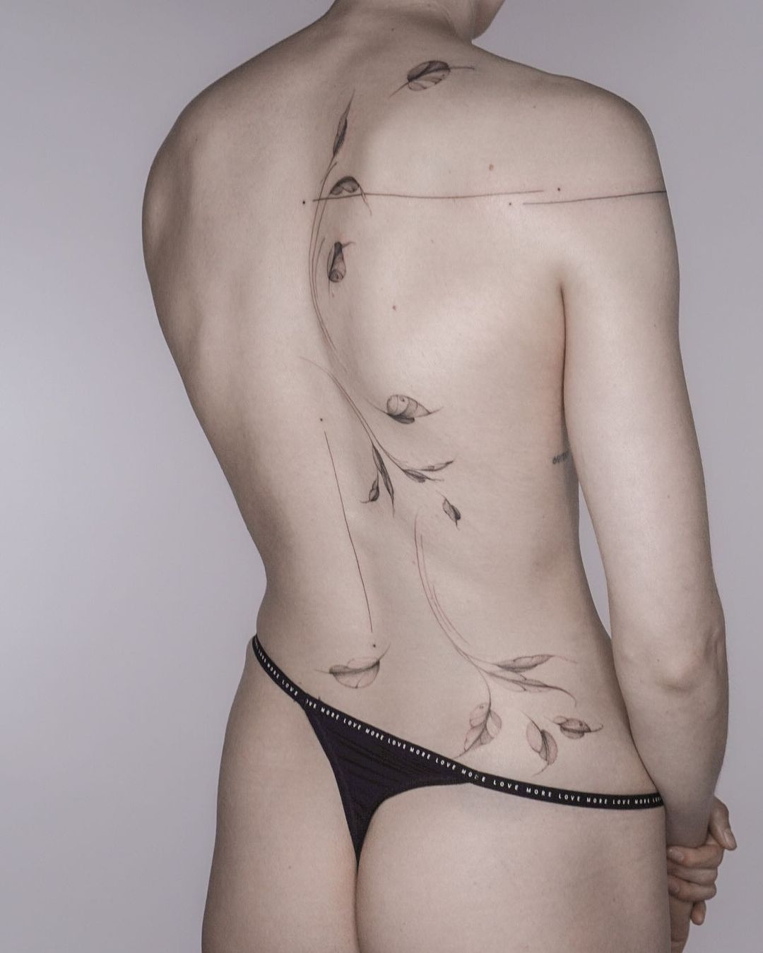 ornamental flower tattoo on the back of a woman