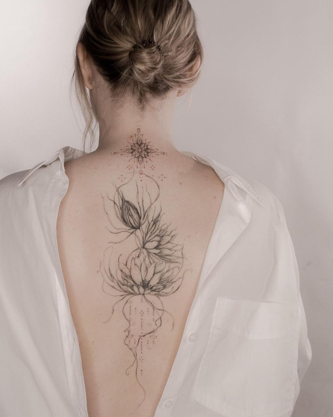 beautiful flower tattoo on the back of a woman