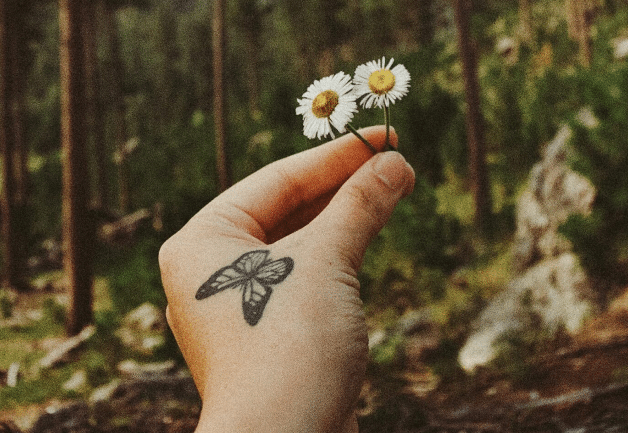 woman with a small butterfly tattoo on her hand