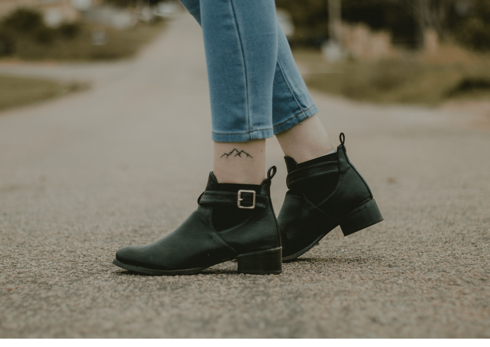 a woman in boots with a tattoo of a silhouette of a mountain on her ankle