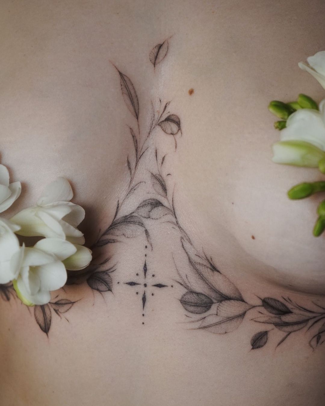 elegant flower tattoo design on the under breast of a woman