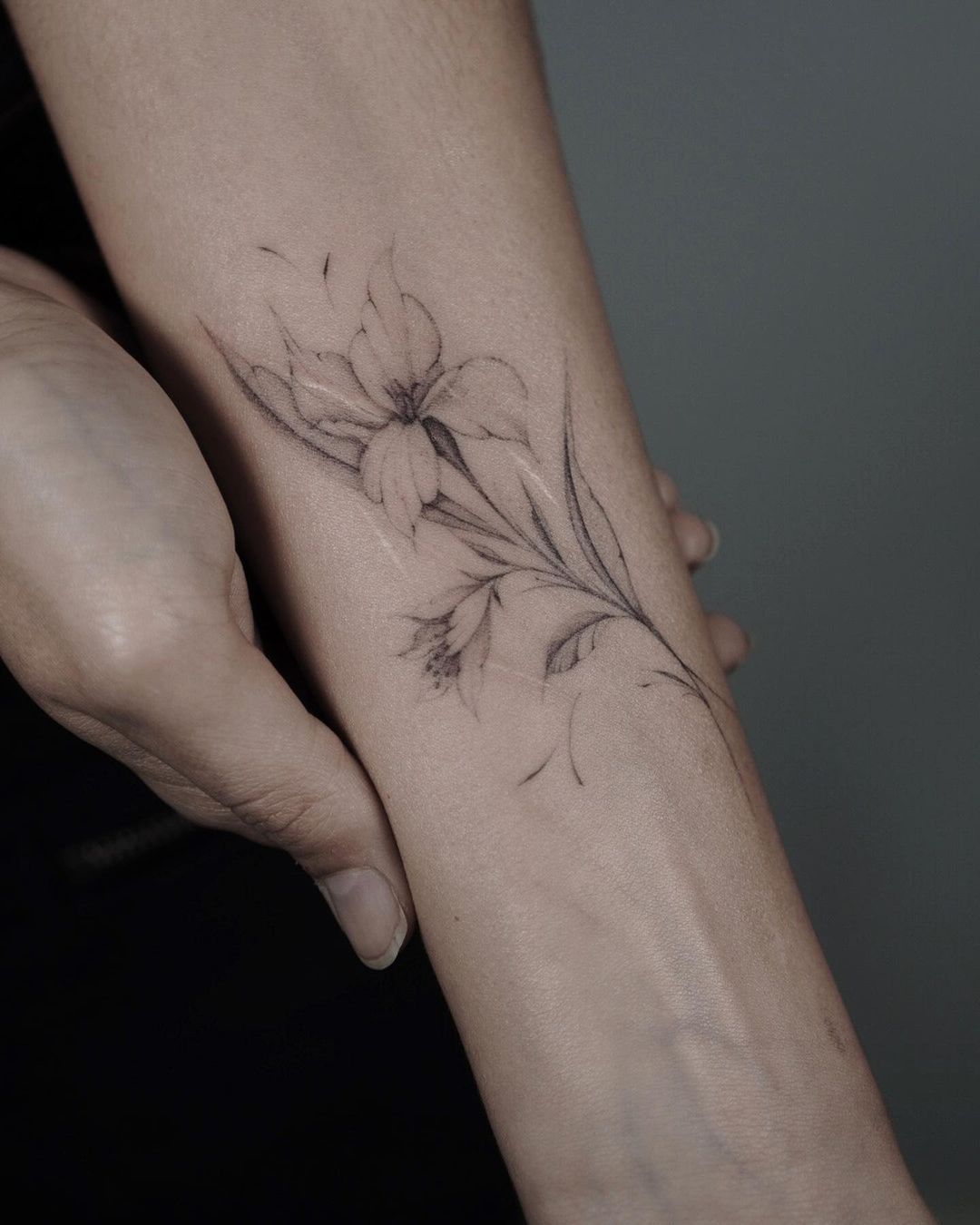 beautiful flower tattoo on the forearm of a woman