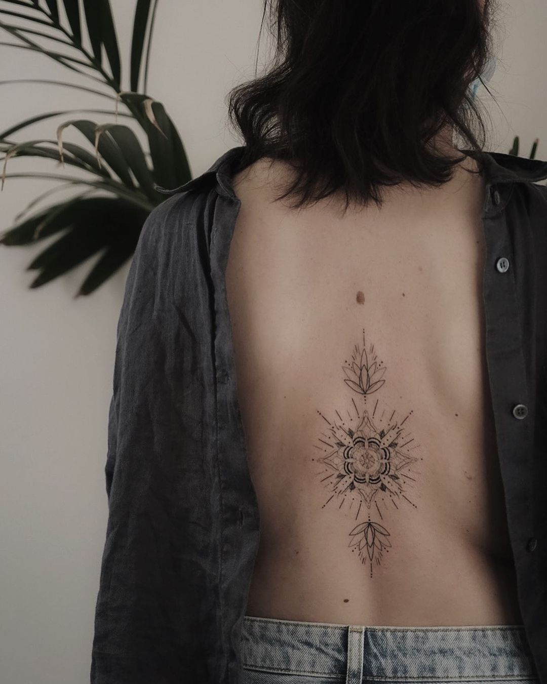 abstract flower tattoo on the back of a woman