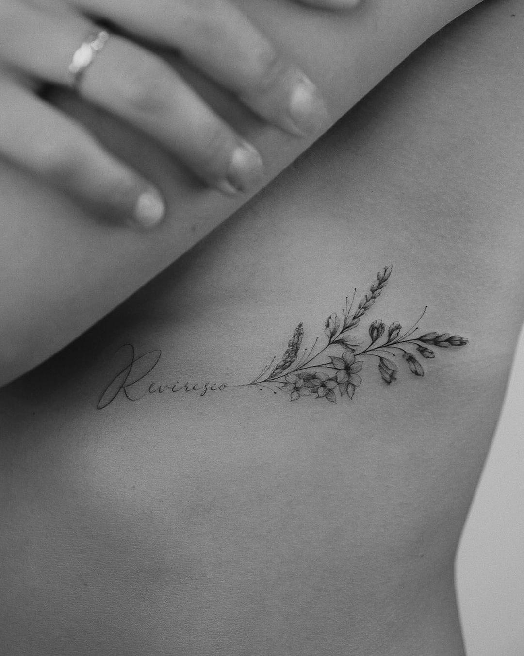 tiny flower tattoo on a womans under breast