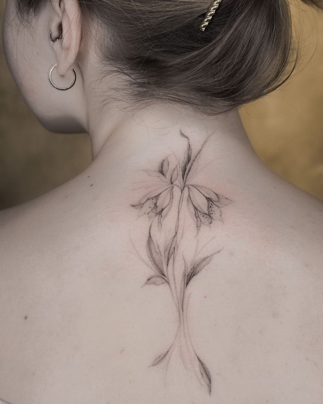 delicate flower tattoo on a womans nape