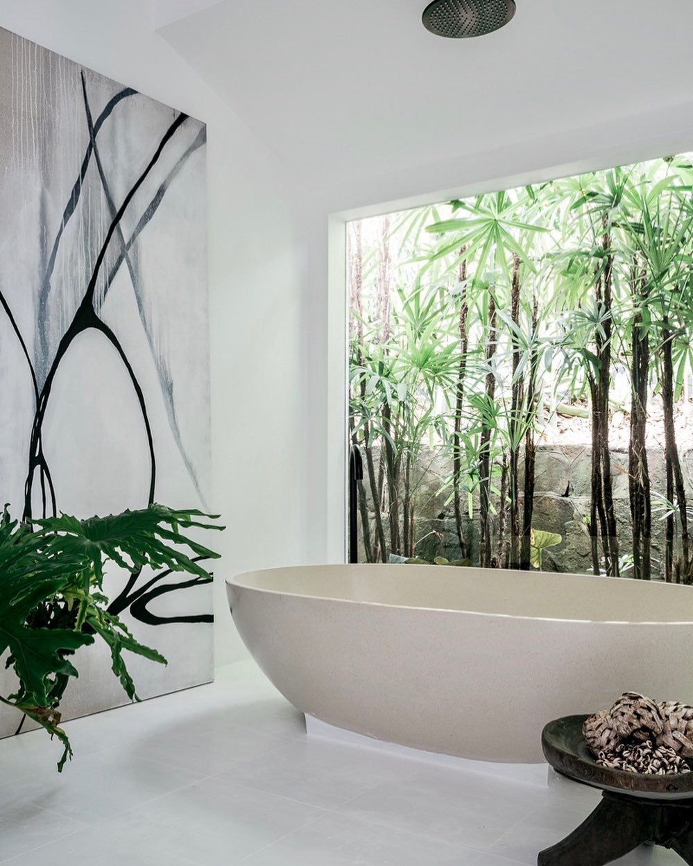 a bathroom with stand alone tub decorated with plants