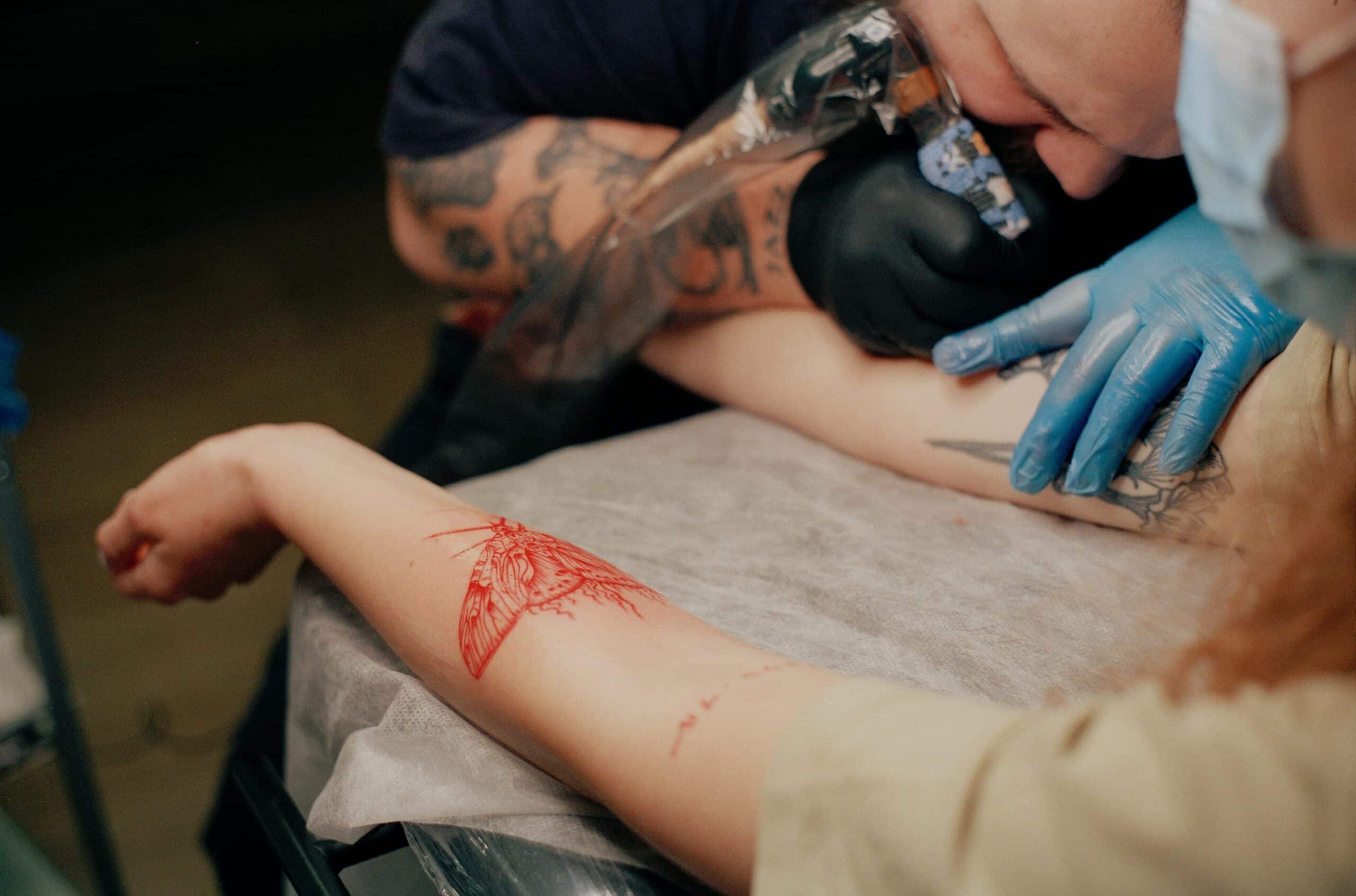 tattoo artist doing fine-line tattoos