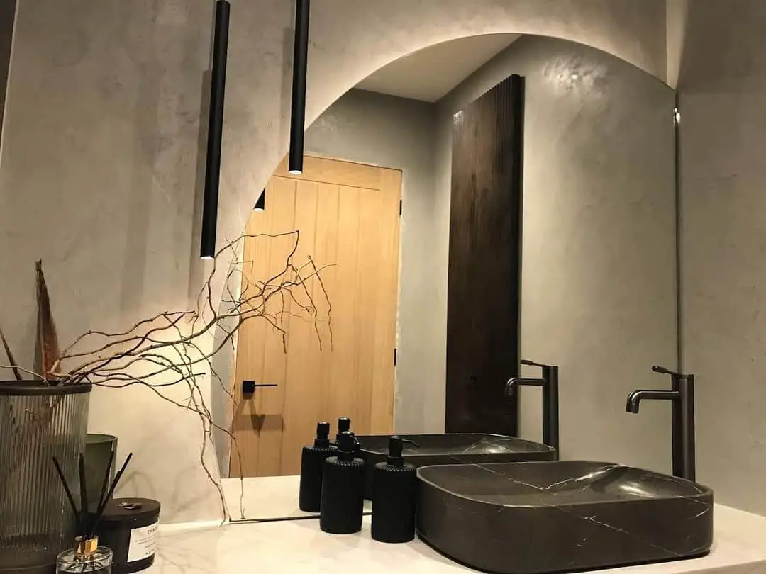 a matte black kitchen faucet and marquina marble twin lavatory