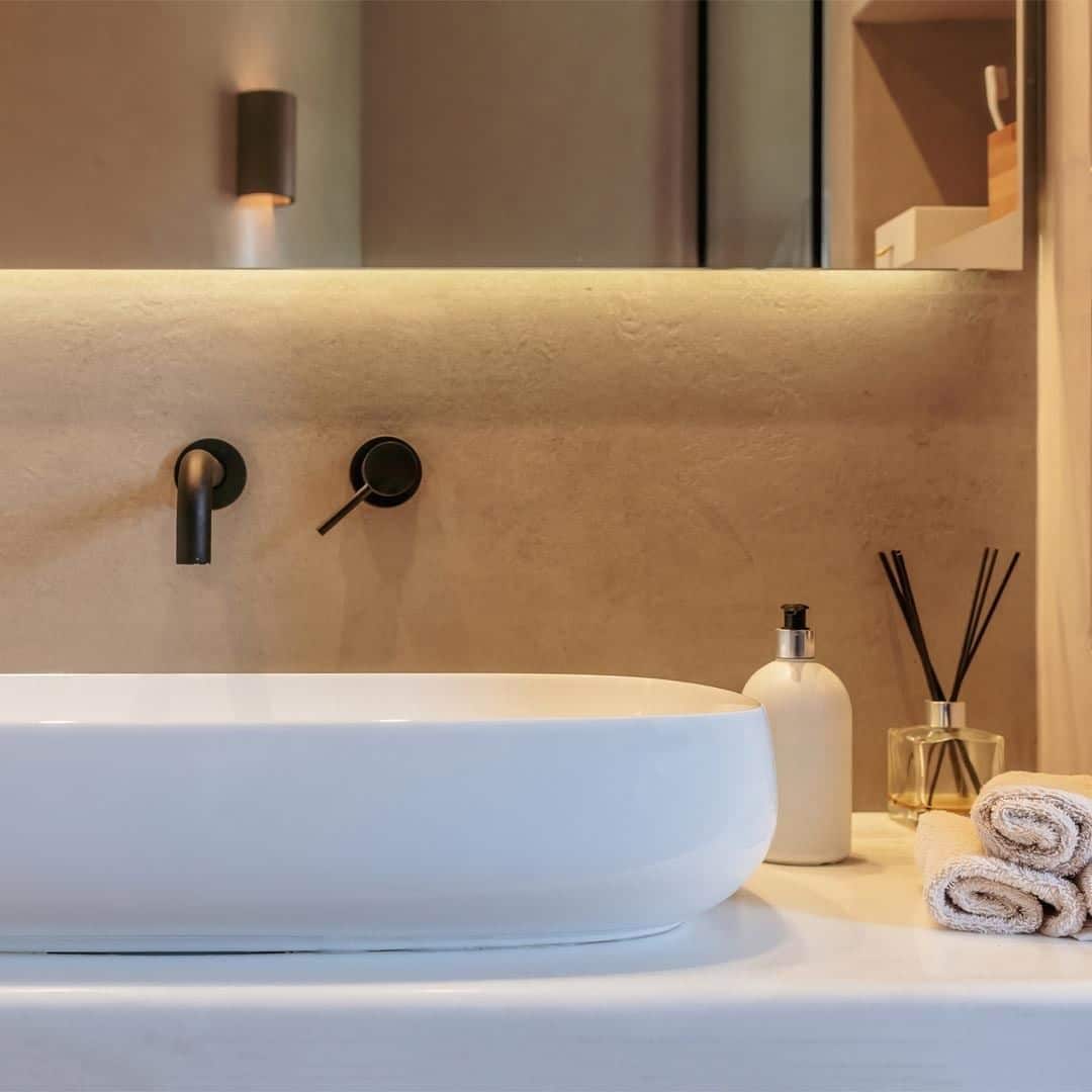 an minimalist mediterranean bathroom design with silken white lavatory and matte black faucet