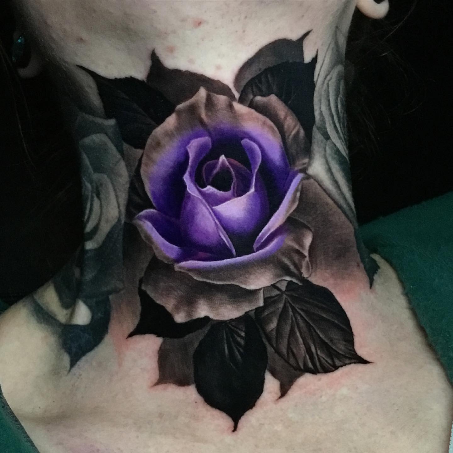 beautiful purple rose tattoo on mans front neck