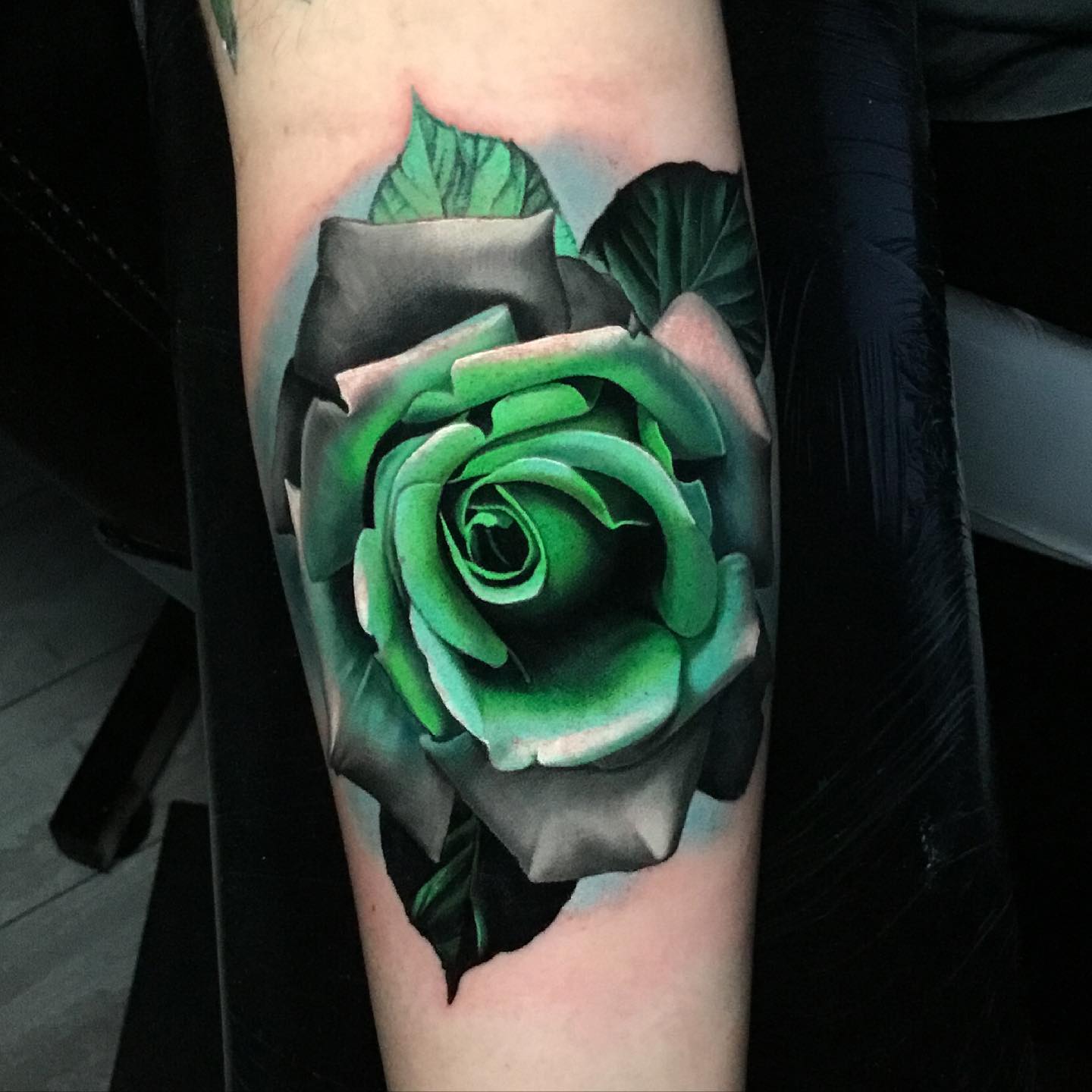 green rose tattoo on the forearm