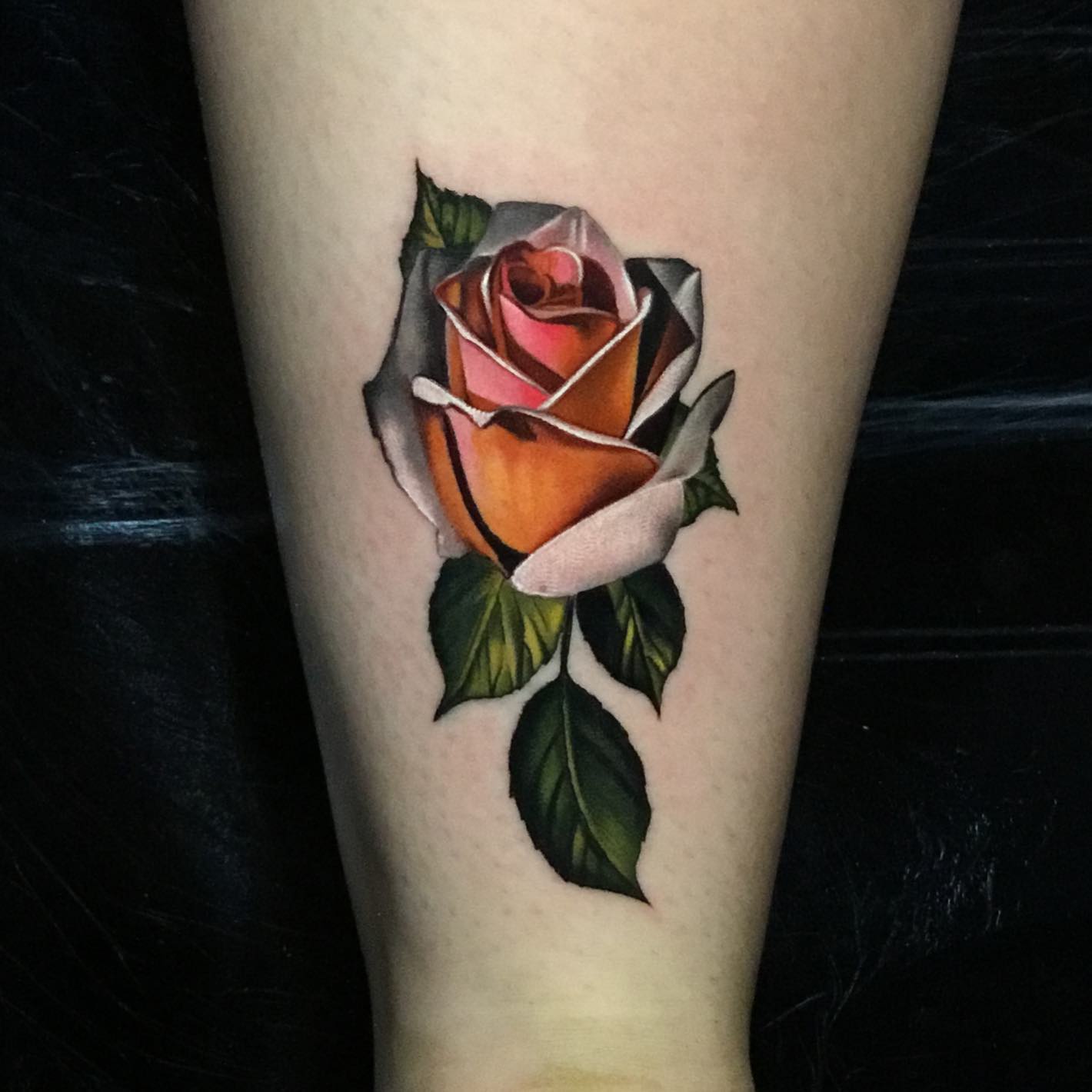 red orange rose tattoo on a womans  calves