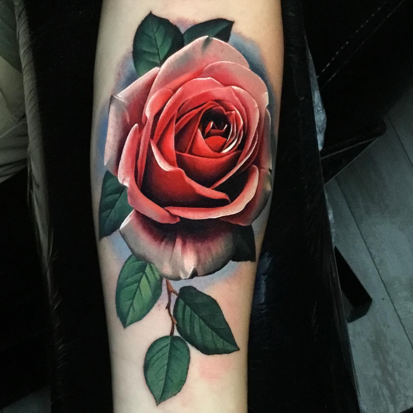 pink rose tattoo on a womans forearm