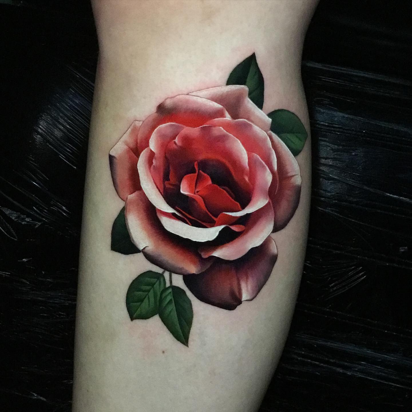 beautiful realistic rose tattoo on womans calves