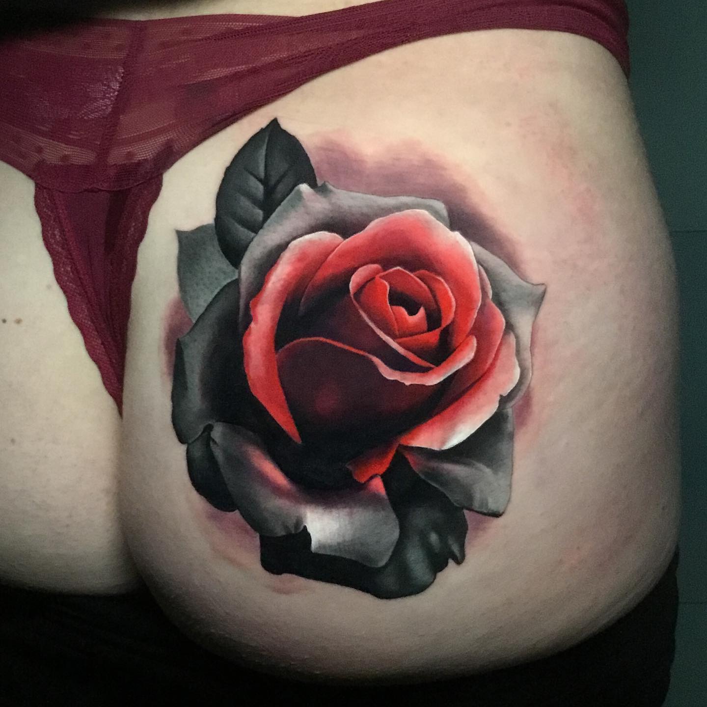 bold rose tattoo on a womans buttocks 
