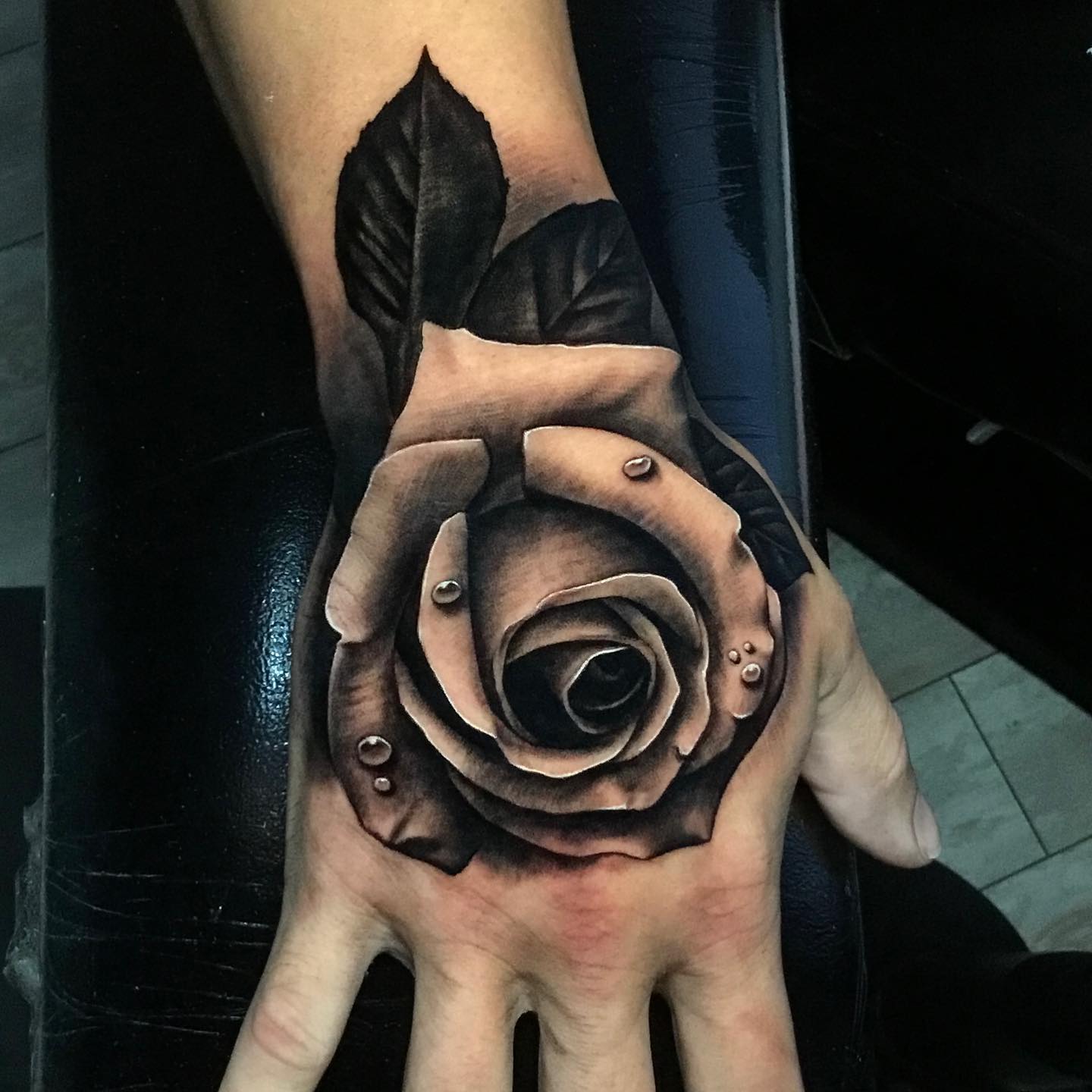 realistic black and gray tattoo on mans hand