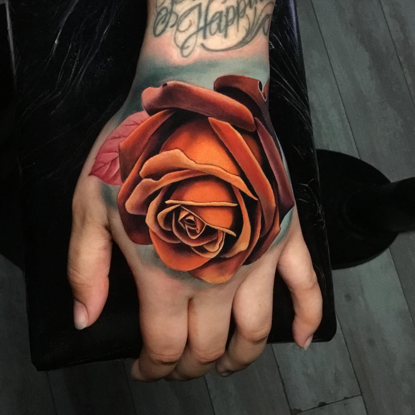 orange rose tattoos on a mans hands