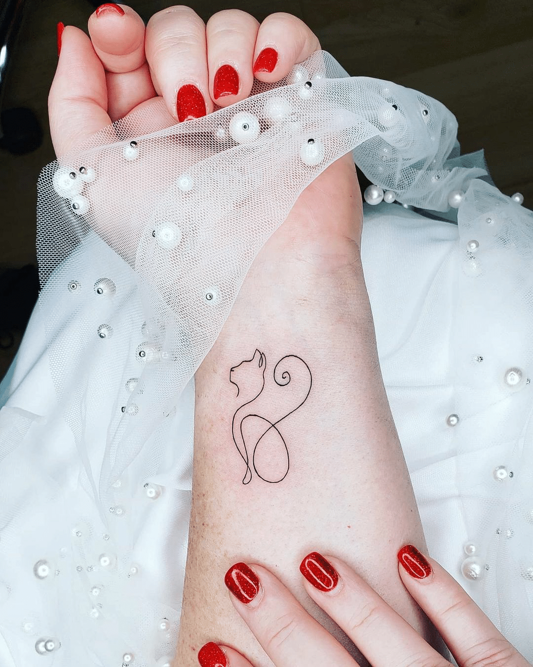 small line art cat tattoo for women