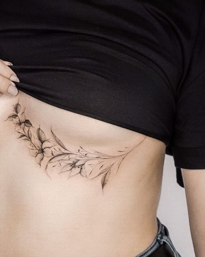 beautiful flower tattoo under the breast of a woman